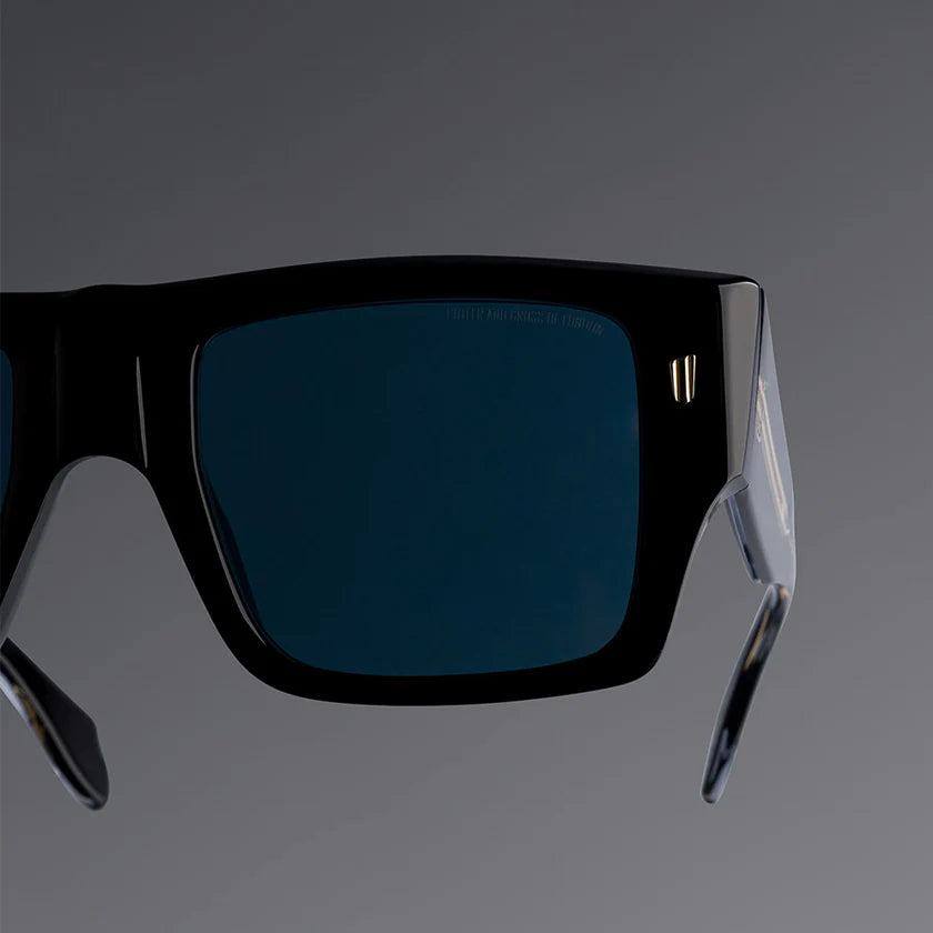 Black sunglasses with blue lenses on a gray background
