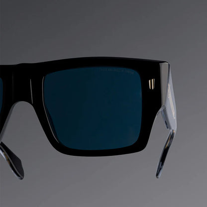 Black sunglasses with blue lenses on a gray background